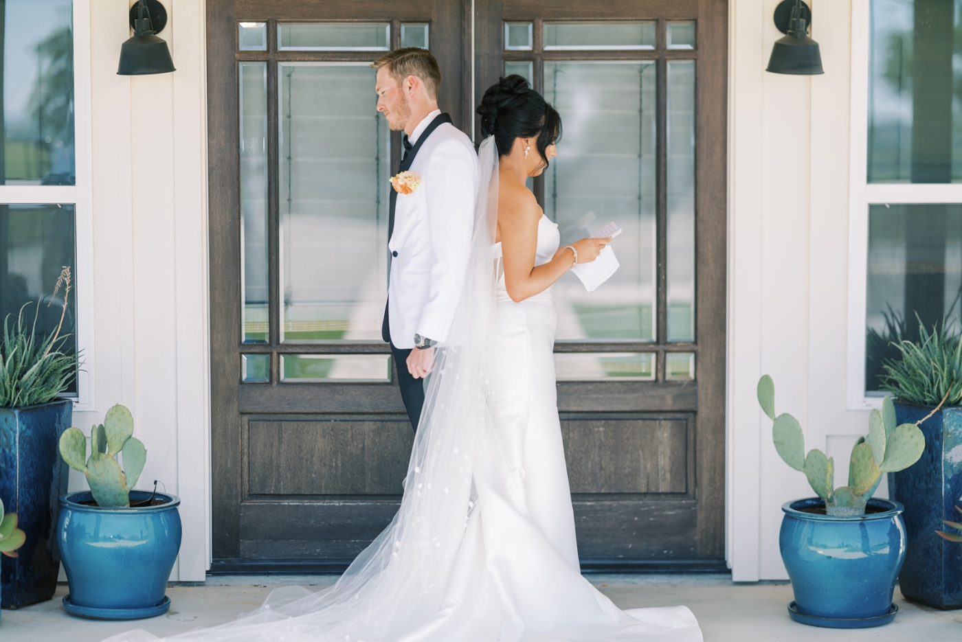 A bride and groom stand on a porch at a North Texas wedding venue and exchange private vows