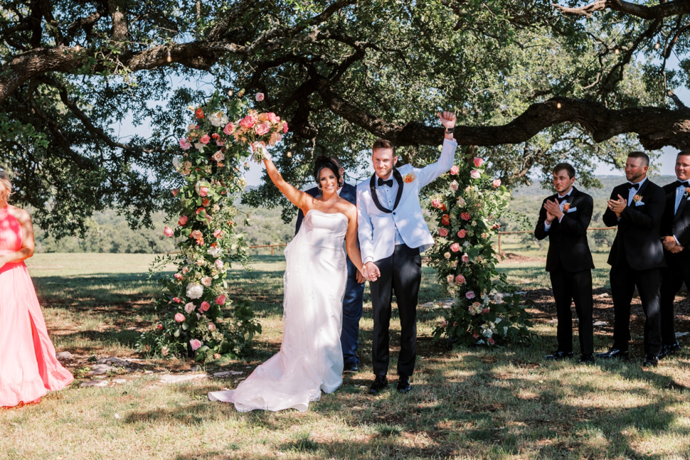 Wedding guests cheer as a bride and groom are announced husband and wife at a North Texas wedding venue