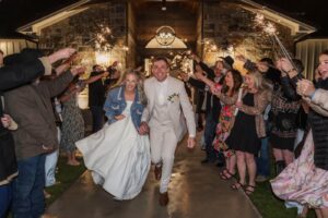 A bride and groom leaving a Texas wedding beneath sparklers held by guests