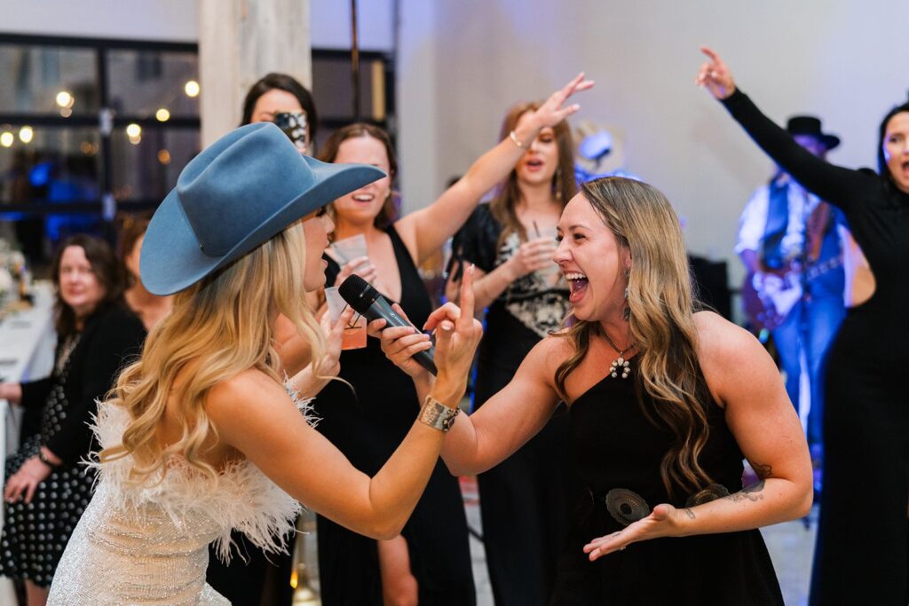 Bride singing with her bridesmaids at Diamond A Ranch wedding reception.