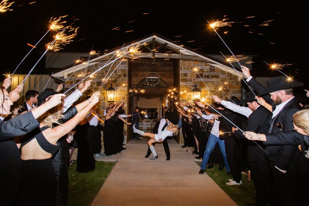 Groom dipping his bride during their sparkler grand exit at Diamond A Ranch wedding.
