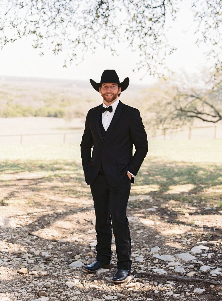 Groom standing outside at his Diamond A Ranch wedding in Texas.