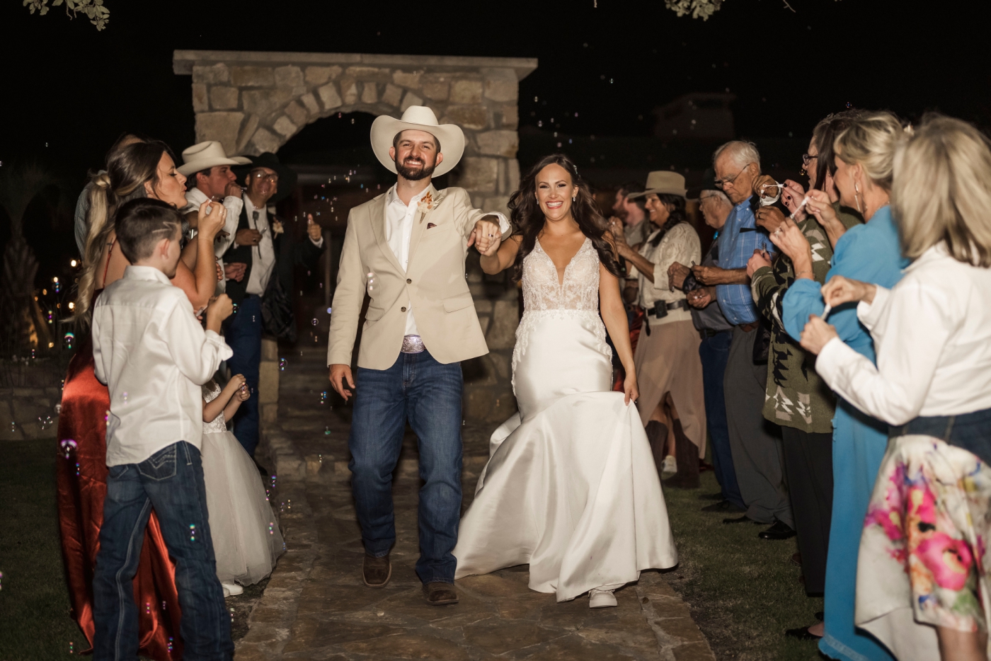 A bride and groom leave their micro wedding under a shower of bubbles 