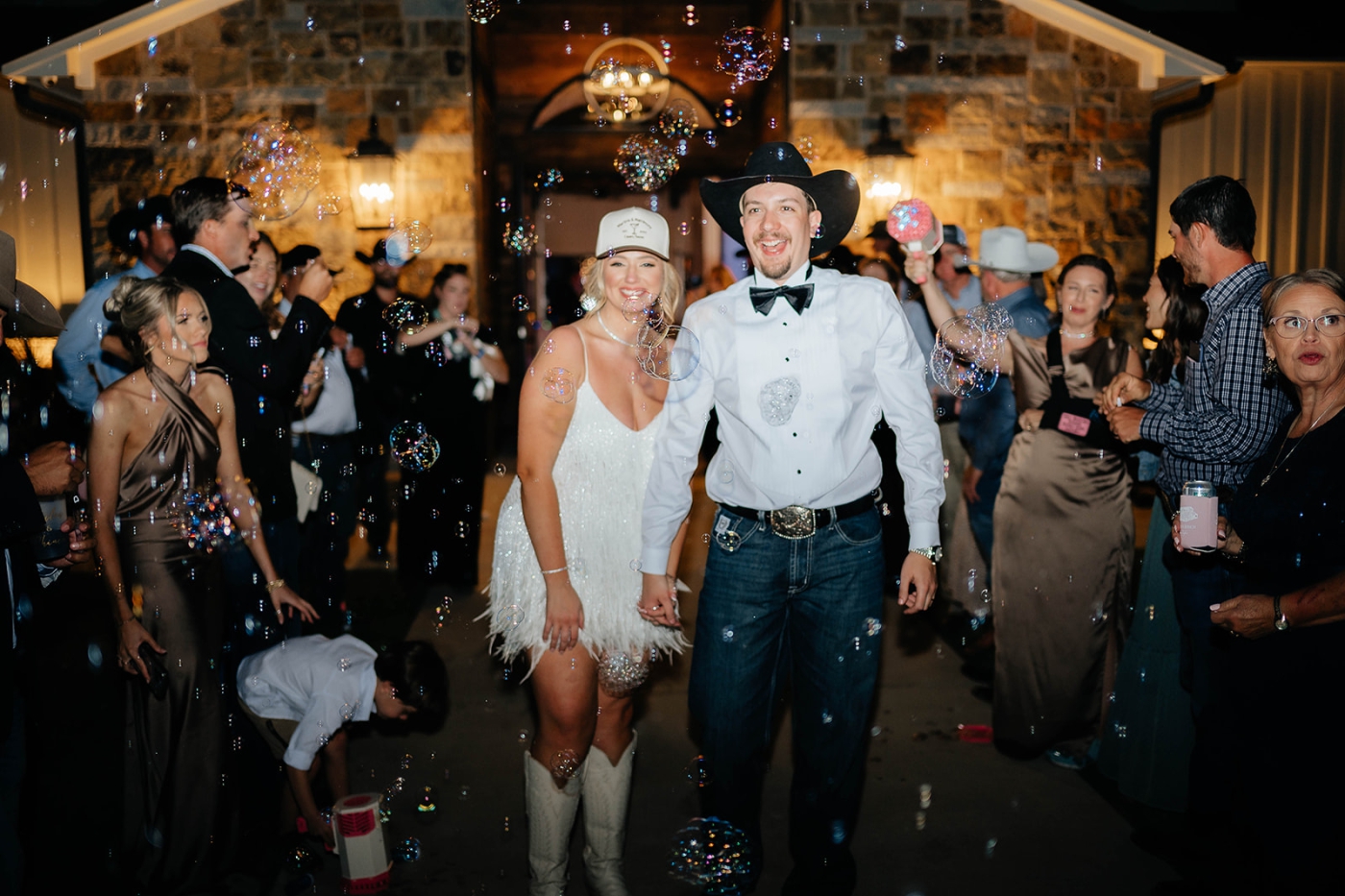 A bride and groom being showered with bubbles during their grand exit
