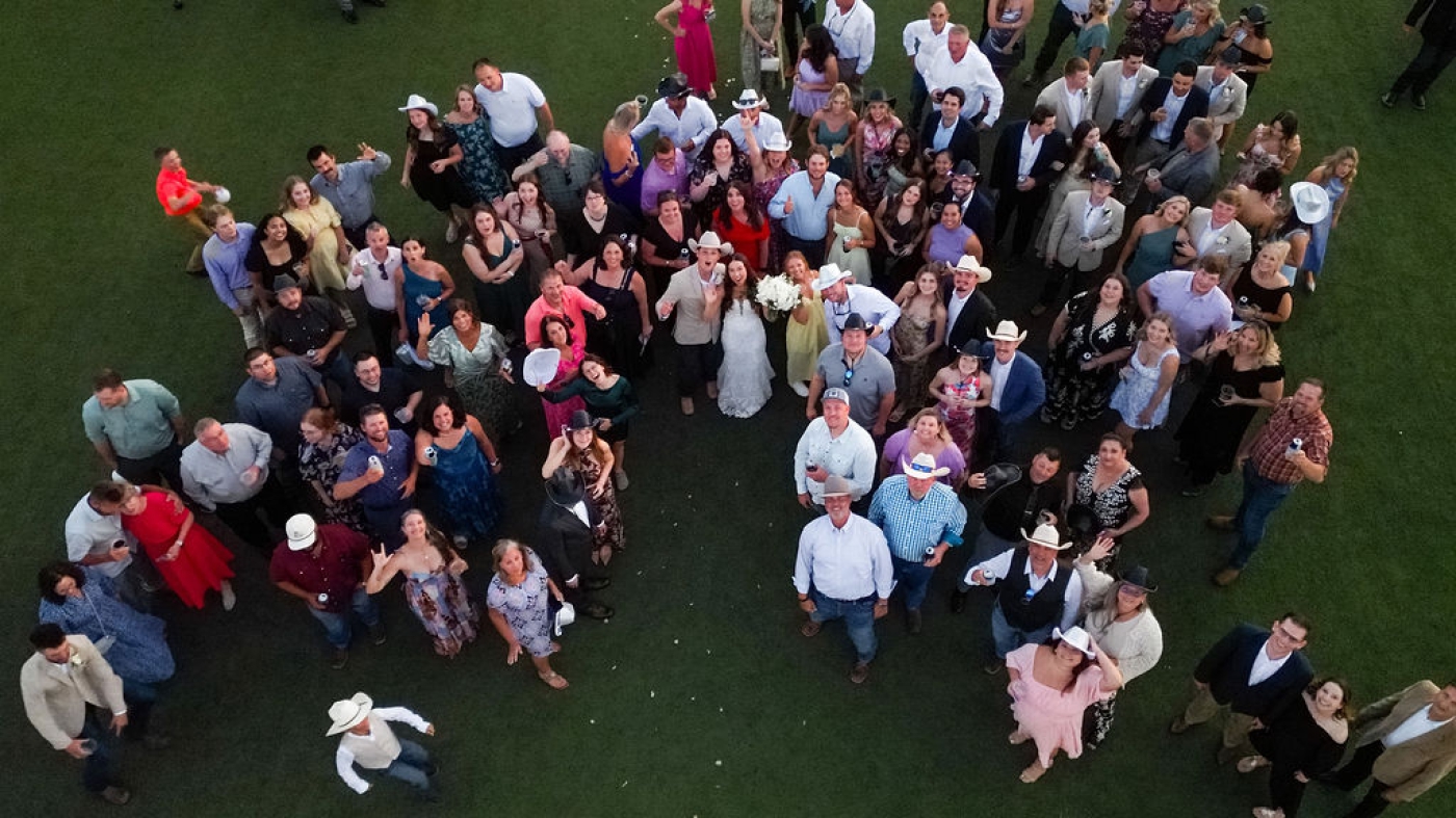 Wedding guests gathered on the grass during a wedding reception at the Diamond A Ranch in Texas