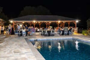 A rehearsal dinner in Fort Worth, Texas, beneath a covered gazebo by an inground pool