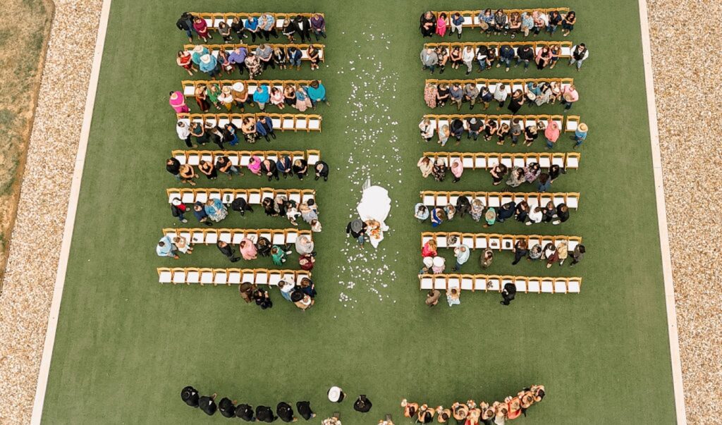 An aerial view of a bride walking down the aisle at the Diamond A Ranch