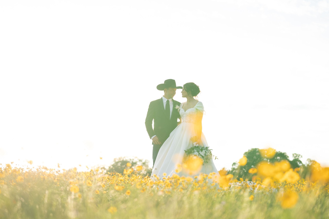 Bride and groom in a field of yellow wildflowers