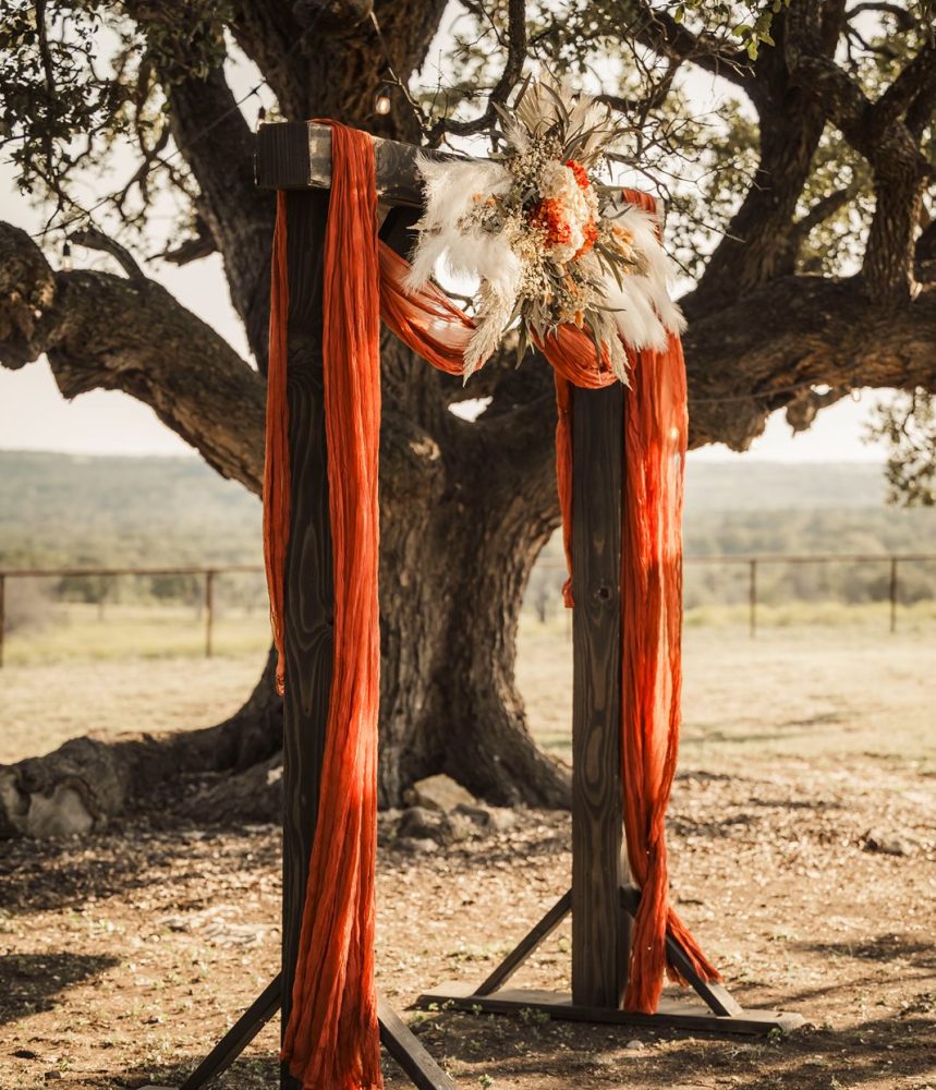 wood-ceremony-arch-with-red-drape custom wood ceremony arch with red drape and feathers